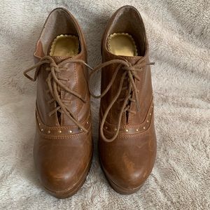 Tan lace up high heel boots.